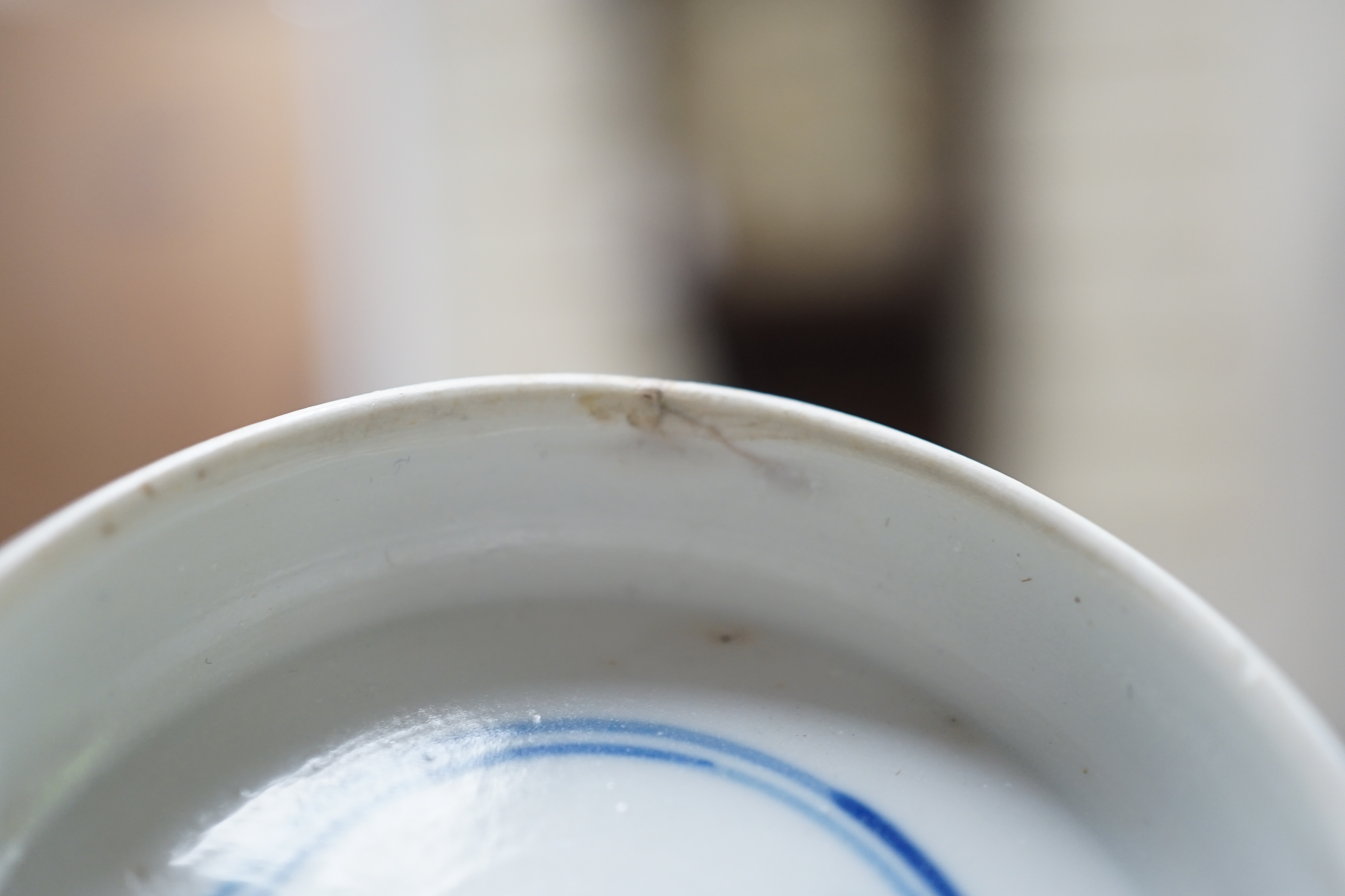 A near pair of Chinese blue and white ‘birds’ bowls, Kangxi period, one bowl restored